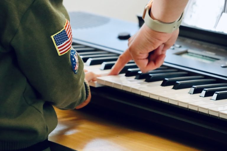 Child at the piano pressing down keys